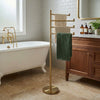 Freestanding 4 Pivoting Swing Arm Towel Stand shown in the Unlacquered Brass finish in a bathroom setting